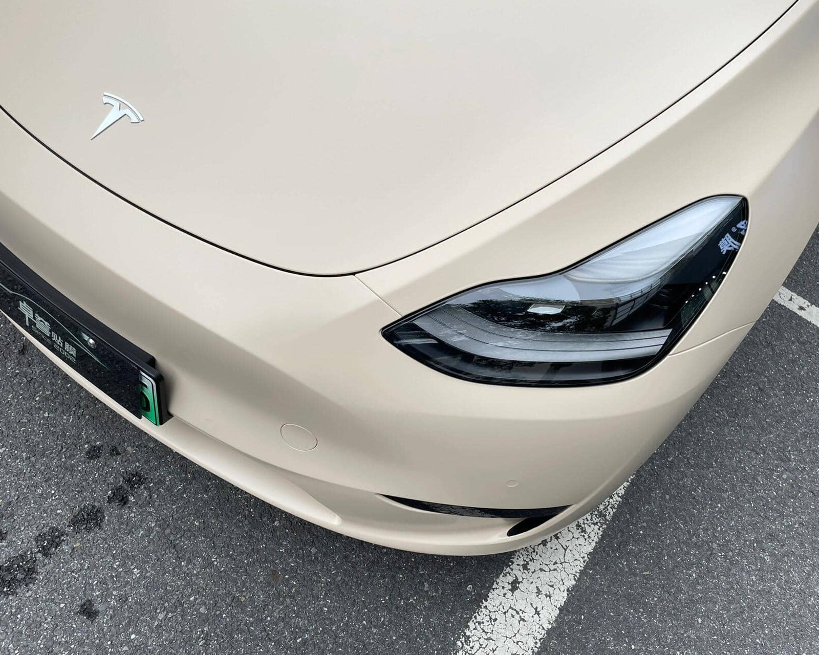 Front corner of Tesla car with matte MATTE SPACE GRAY tesla wrap showing headlight and hood details