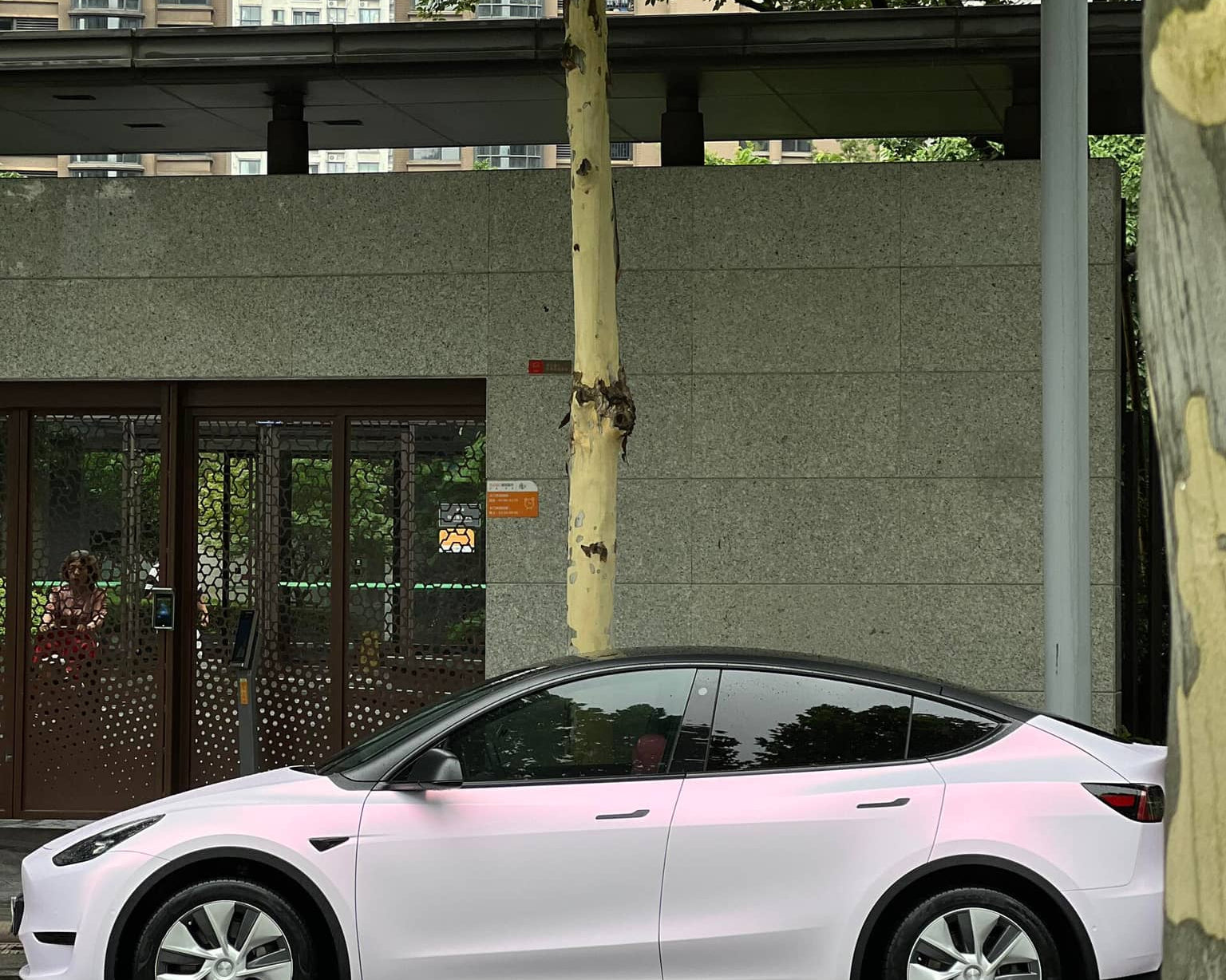 WrapBug pink car wrap on white Tesla Model Y parked on city street