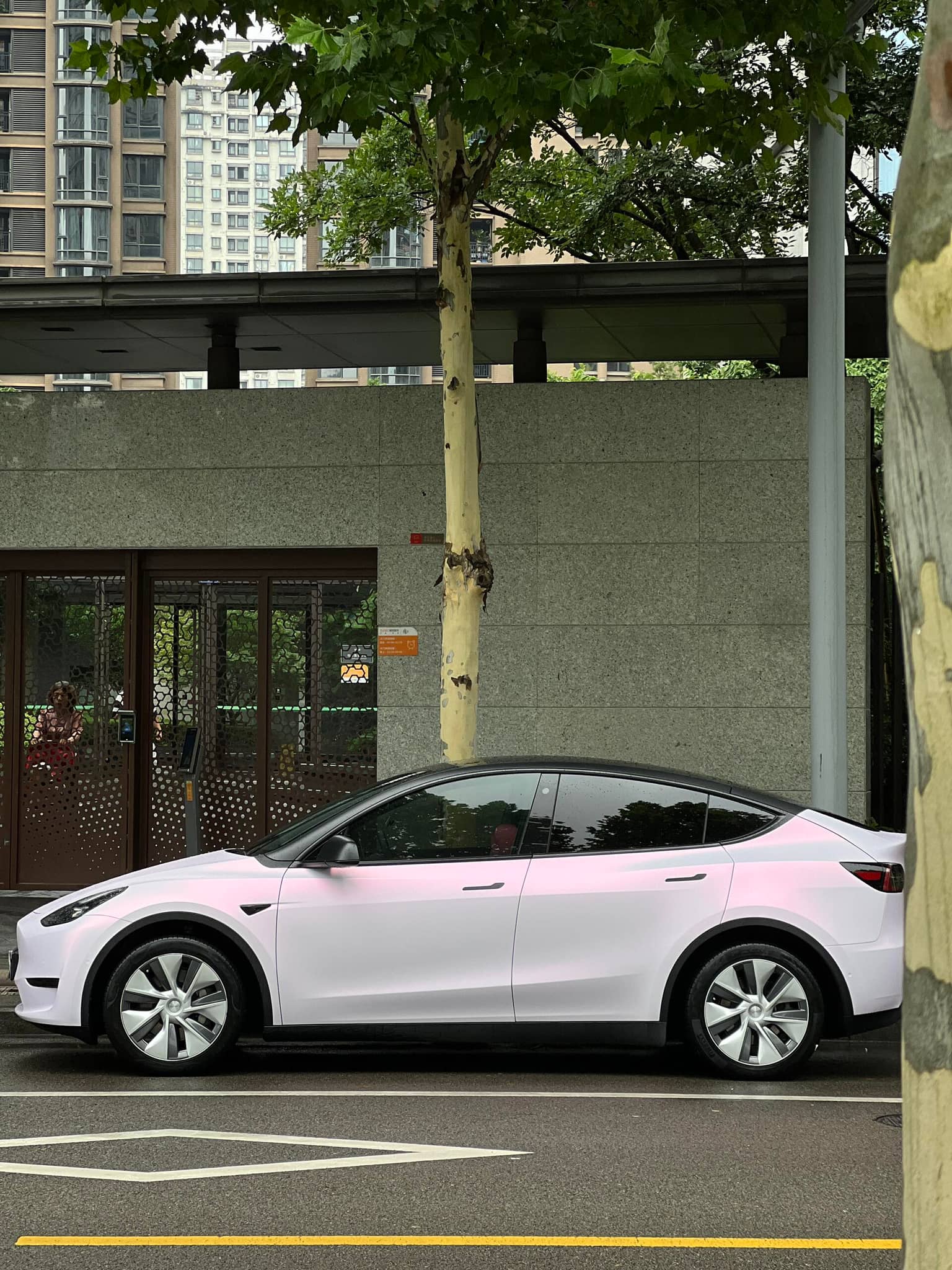 WrapBug pink car wrap on white Tesla Model Y parked on city street