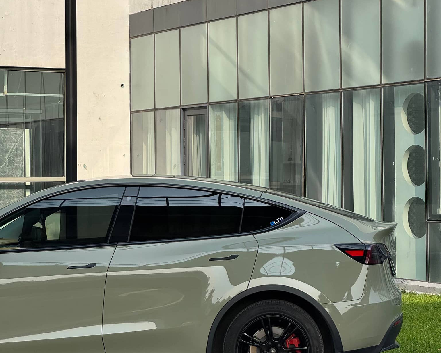 Taupe Tesla Model Y with black wheels featuring WrapBug Pre-cut Tesla Vinyl Wrap Kit exterior