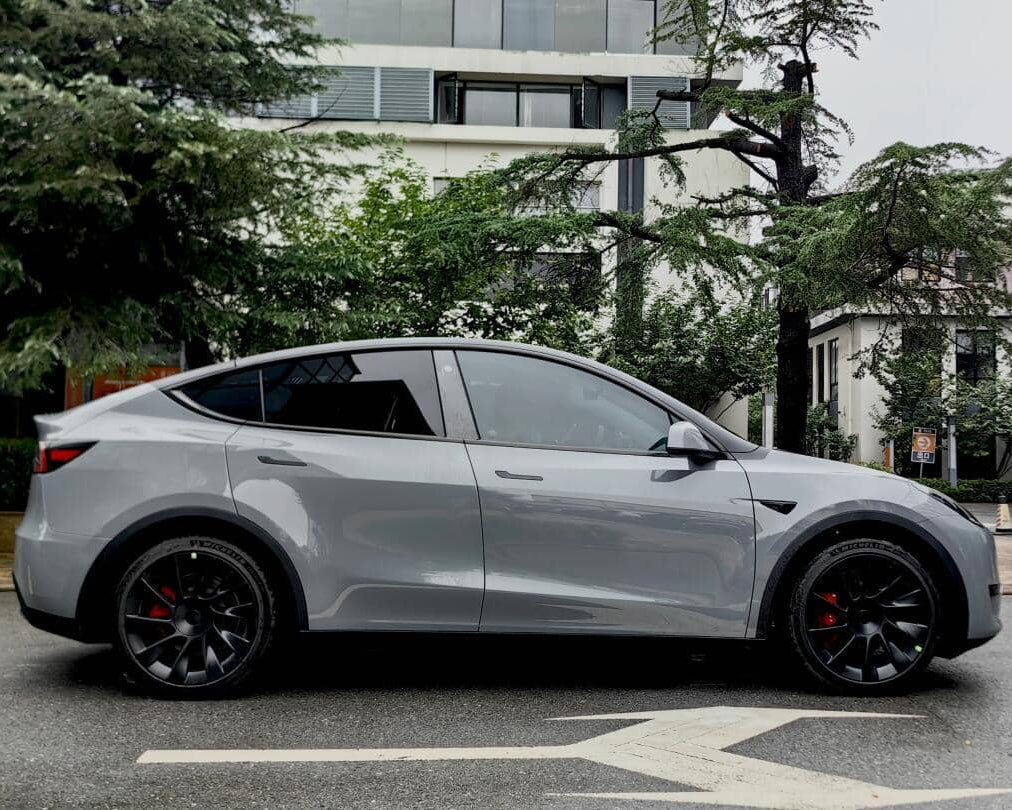 Silver Tesla Model Y wrapped with a Pre-cut Tesla Vinyl Wrap Kit parked on the street