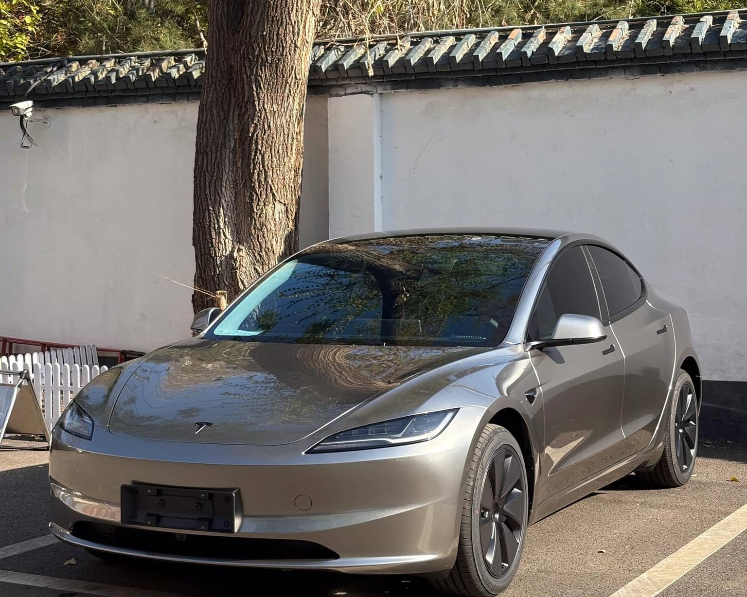 Silver Tesla Model 3 parked outdoors featuring WrapBug pre-cut Tesla wrap kit applied
