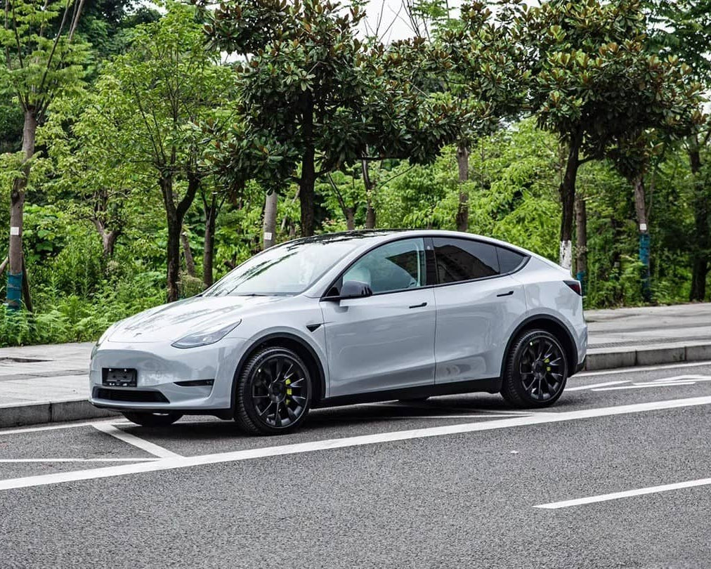 Silver Tesla Model Y parked on street showcasing WrapBug pre-cut Tesla wrap kit application