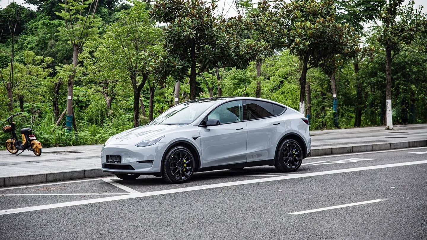 Silver Tesla Model Y parked on street showcasing WrapBug pre-cut Tesla wrap kit application