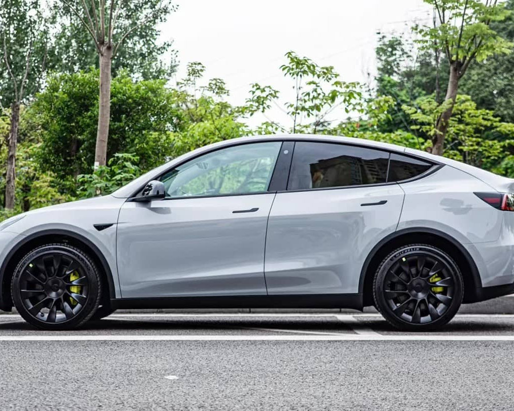 Silver Tesla Model Y parked on street showcasing Pre-cut Tesla Wrap Kit by WrapBug