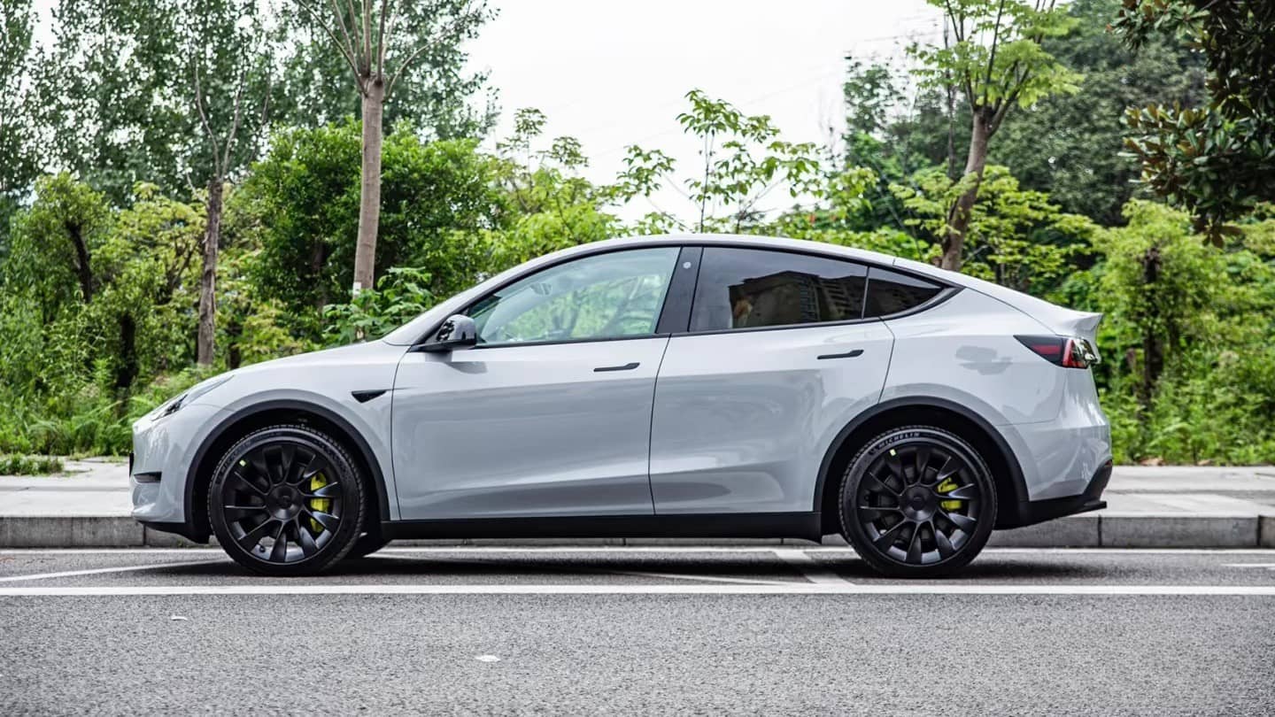 Silver Tesla Model Y parked on street showcasing Pre-cut Tesla Wrap Kit by WrapBug