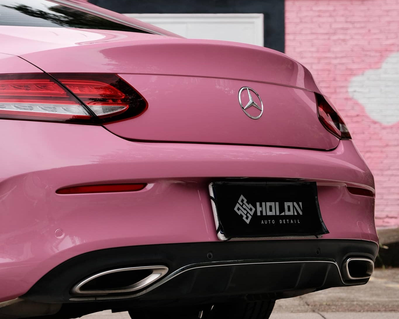 Pink luxury car rear view wrapped with Pre-cut Tesla Wrap Kit by WrapBug in an urban setting