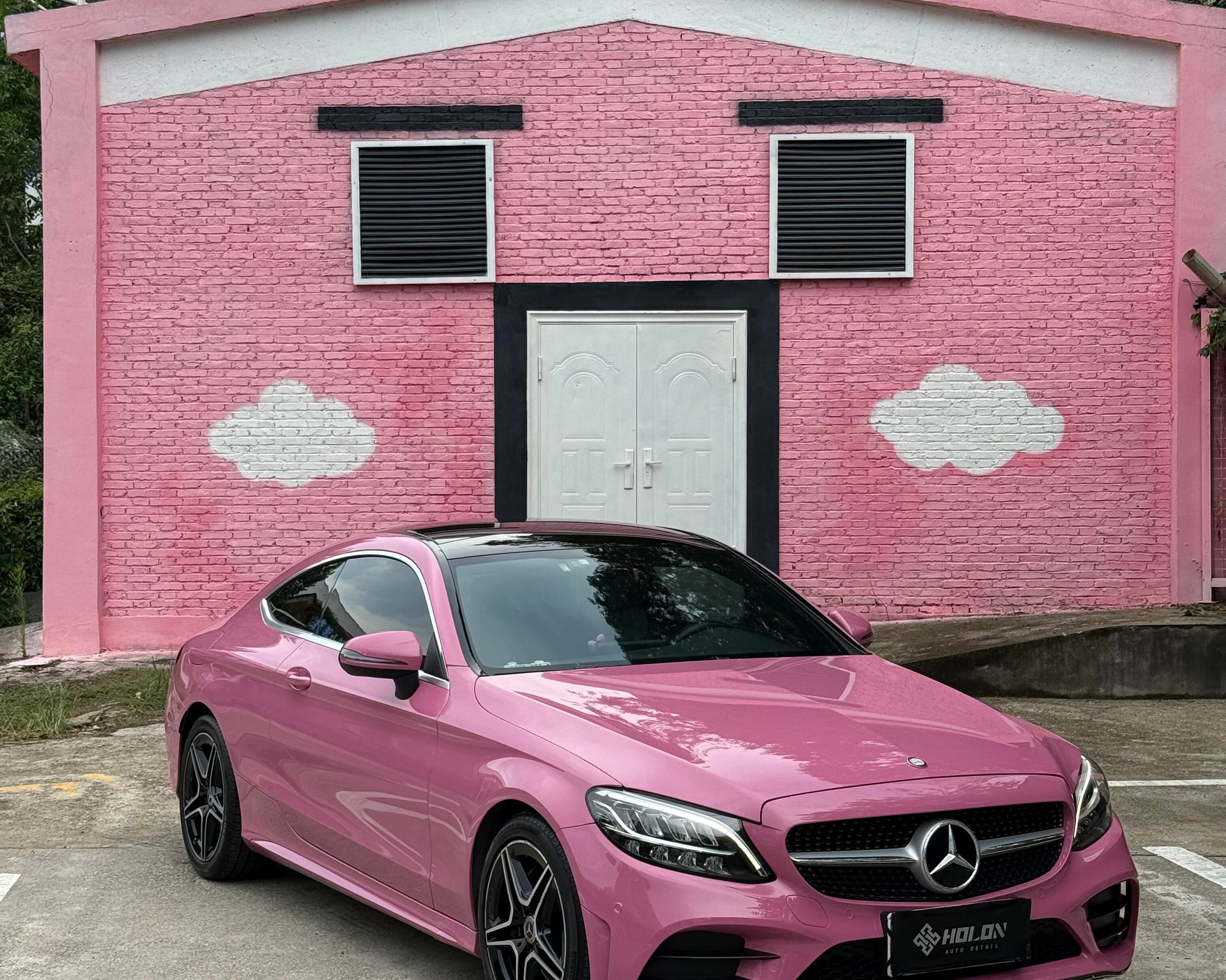 Pink Mercedes parked in front of pink house wall showcasing Pre-cut Tesla Wrap Kit by WrapBug