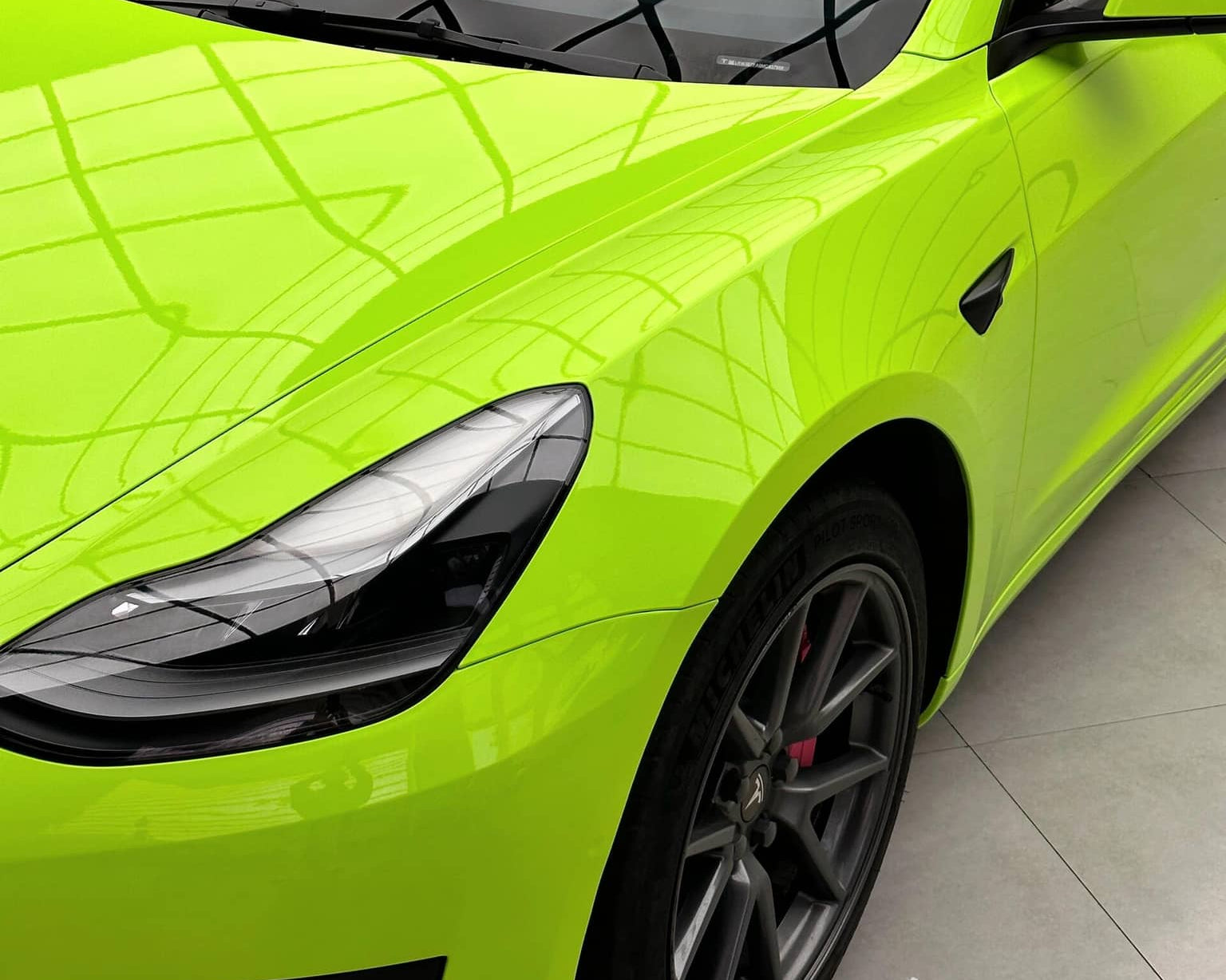 Bright green Tesla Model 3 with a glossy finish applied using a Pre-cut Tesla Wrap Kit by WrapBug