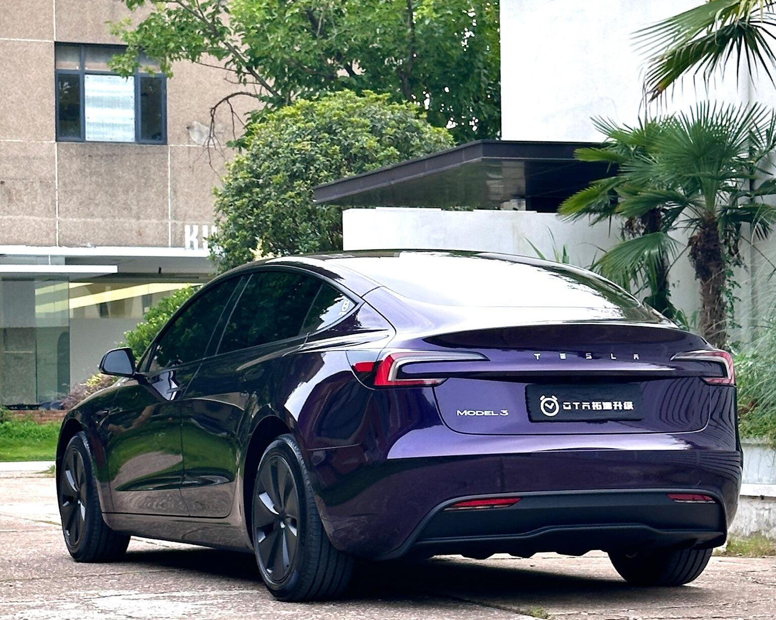 Purple Tesla Model 3 parked outdoors showcasing a smooth finish with a Pre-cut Tesla Wrap Kit from WrapBug