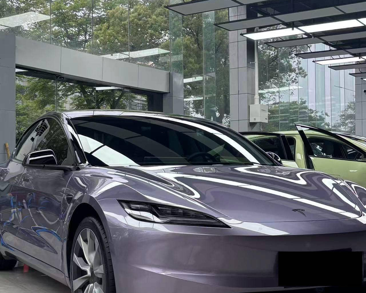 Tesla car with glossy purple finish using a Pre-cut Tesla Wrap Kit by WrapBug in a showroom