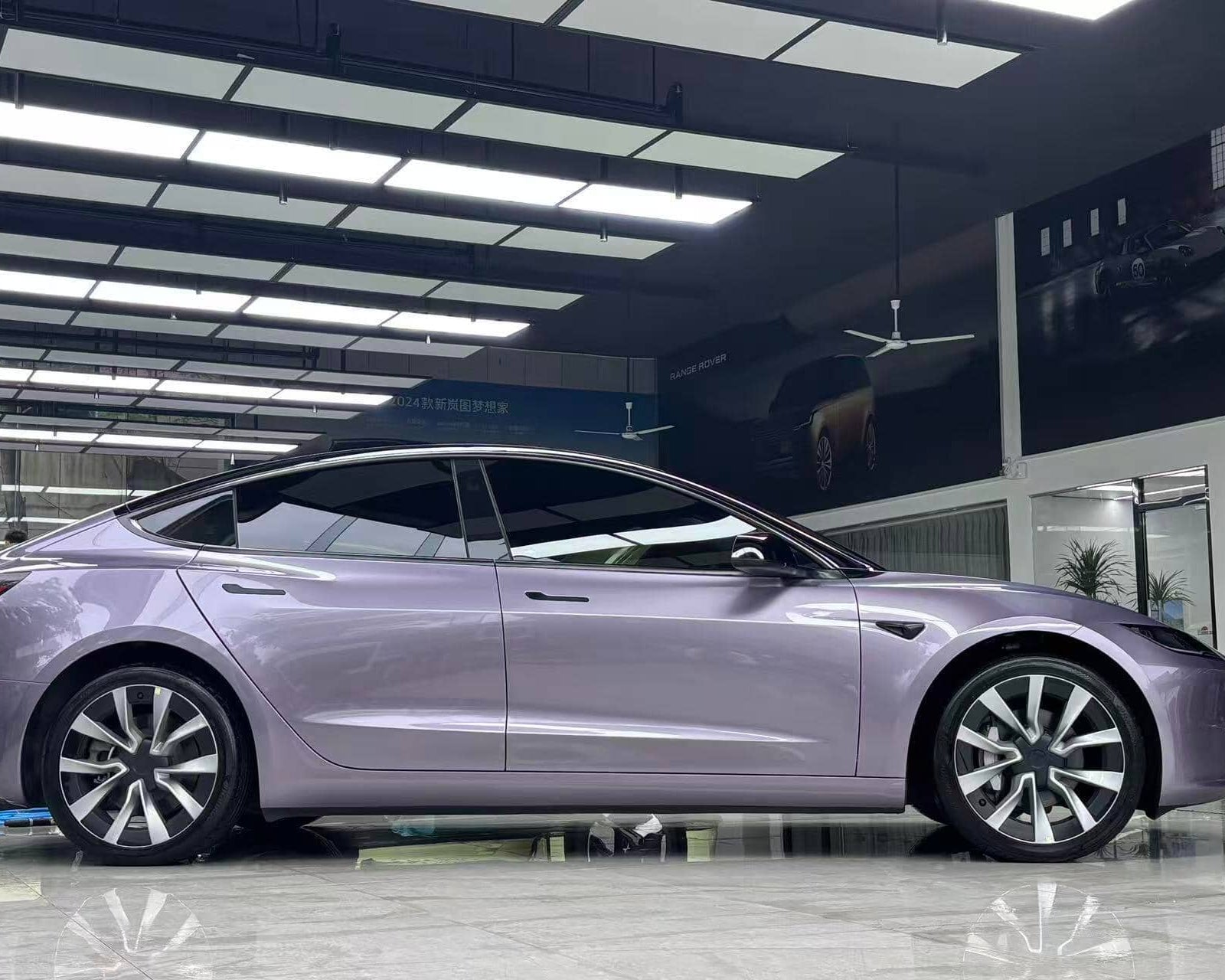 Tesla Model 3 wrapped in purple using WrapBug Pre-cut Tesla Wrap Kit in a showroom