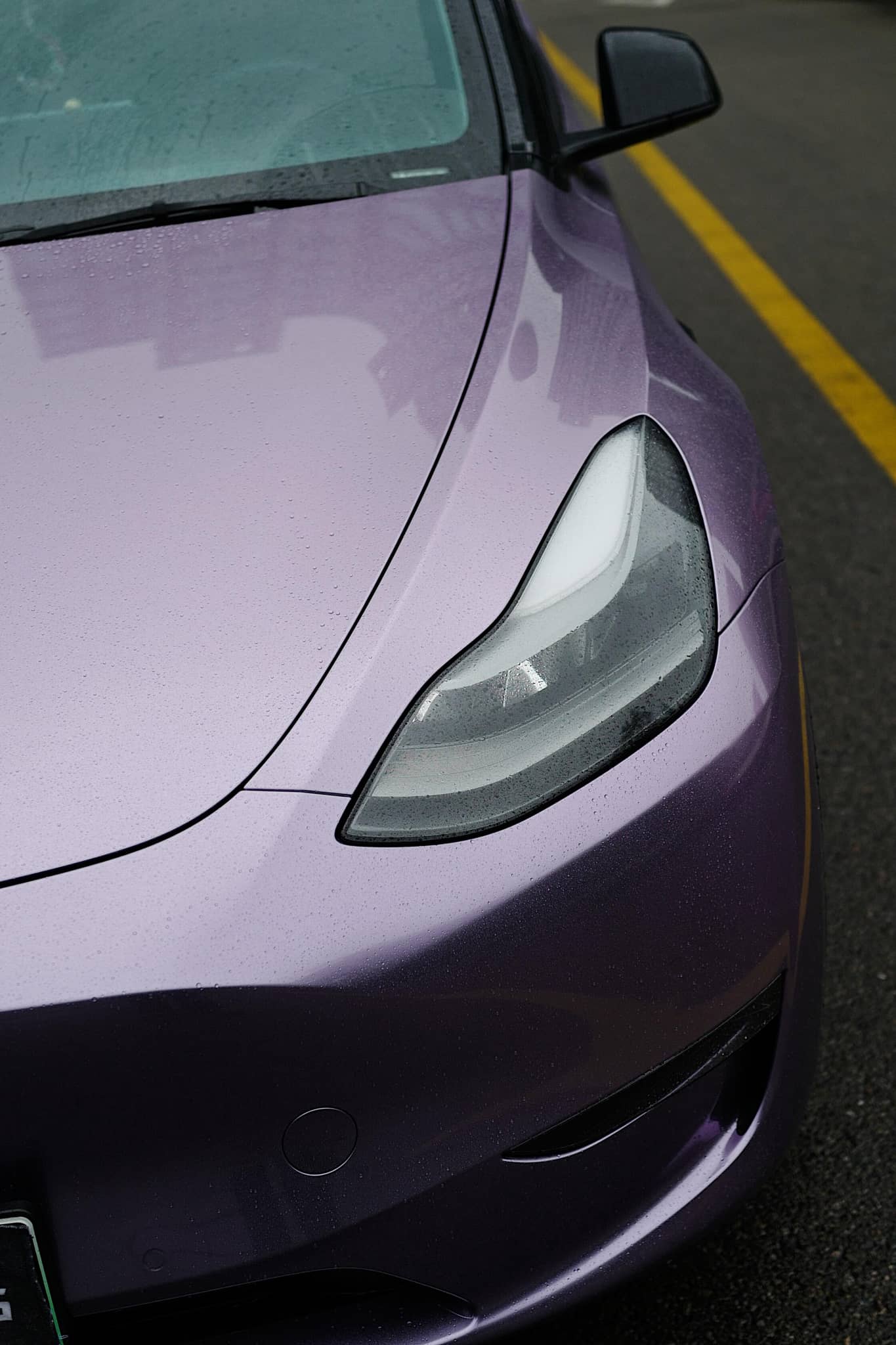 Close-up of a Tesla car front with a purple Pre-cut Tesla Wrap Kit applied on the hood and headlight