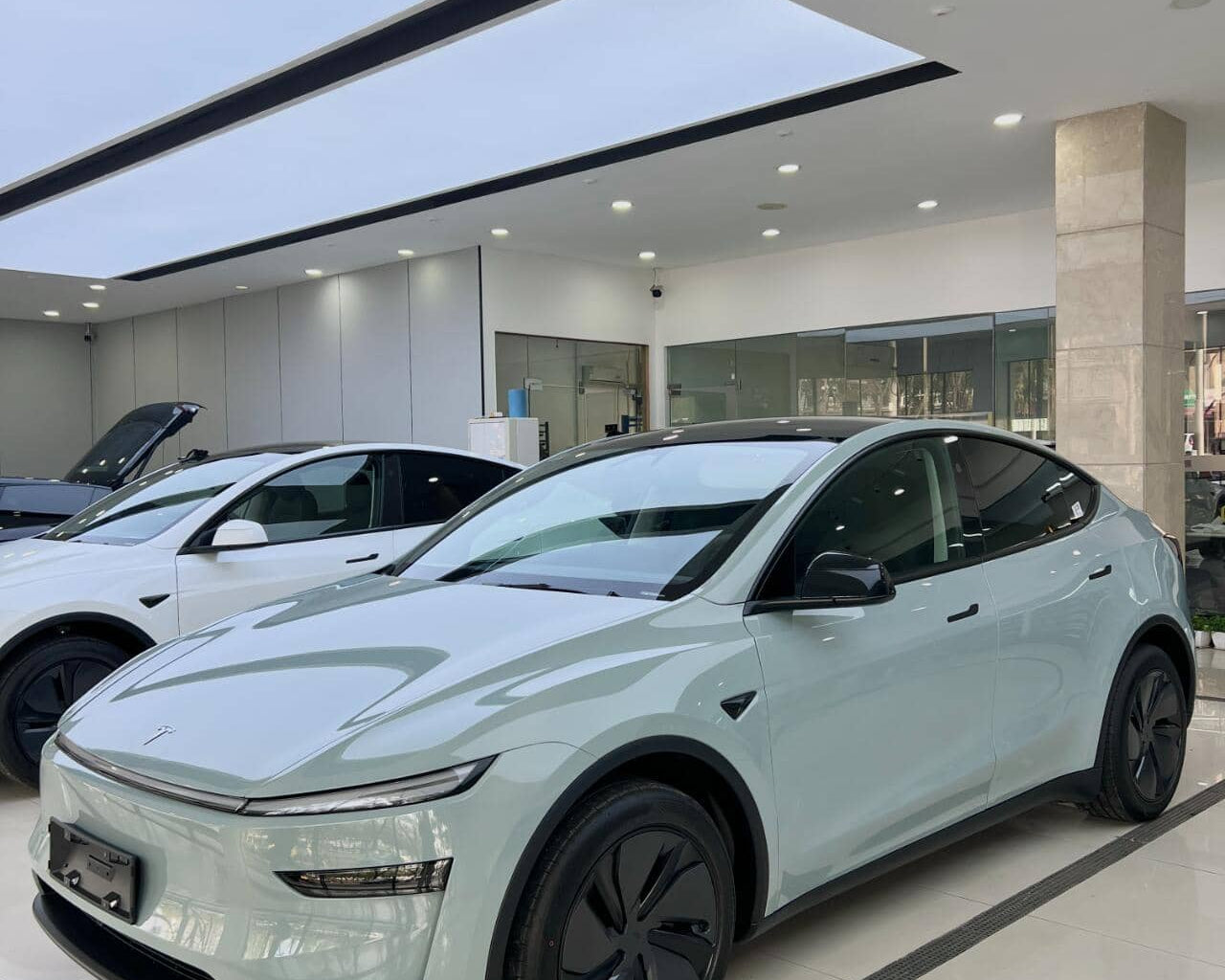 White Tesla SUV featuring sleek design with tesla color PPF in a bright showroom