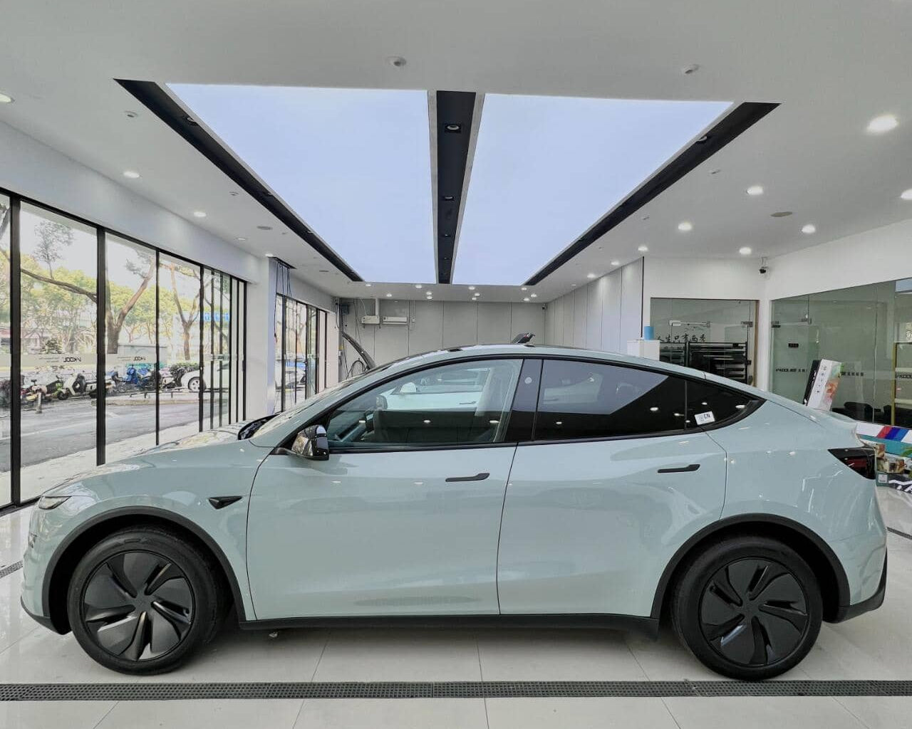White Tesla electric car protected with tesla color PPF film displayed in a bright showroom