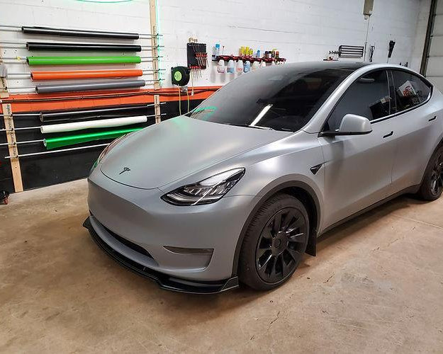 Tesla Model 3 wrapped in matte silver gray tesla model 3 wrap parked in garage with tool racks