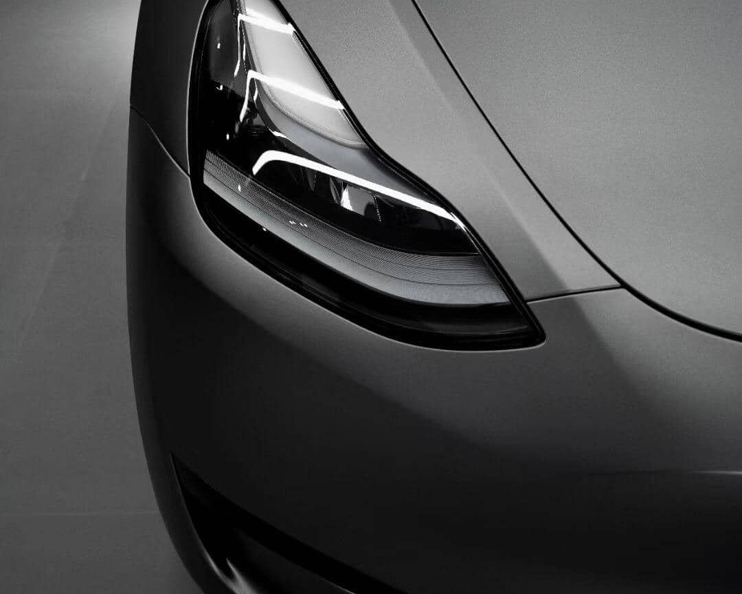 Close-up of a sleek matte gray car front headlight showcasing modern automotive design