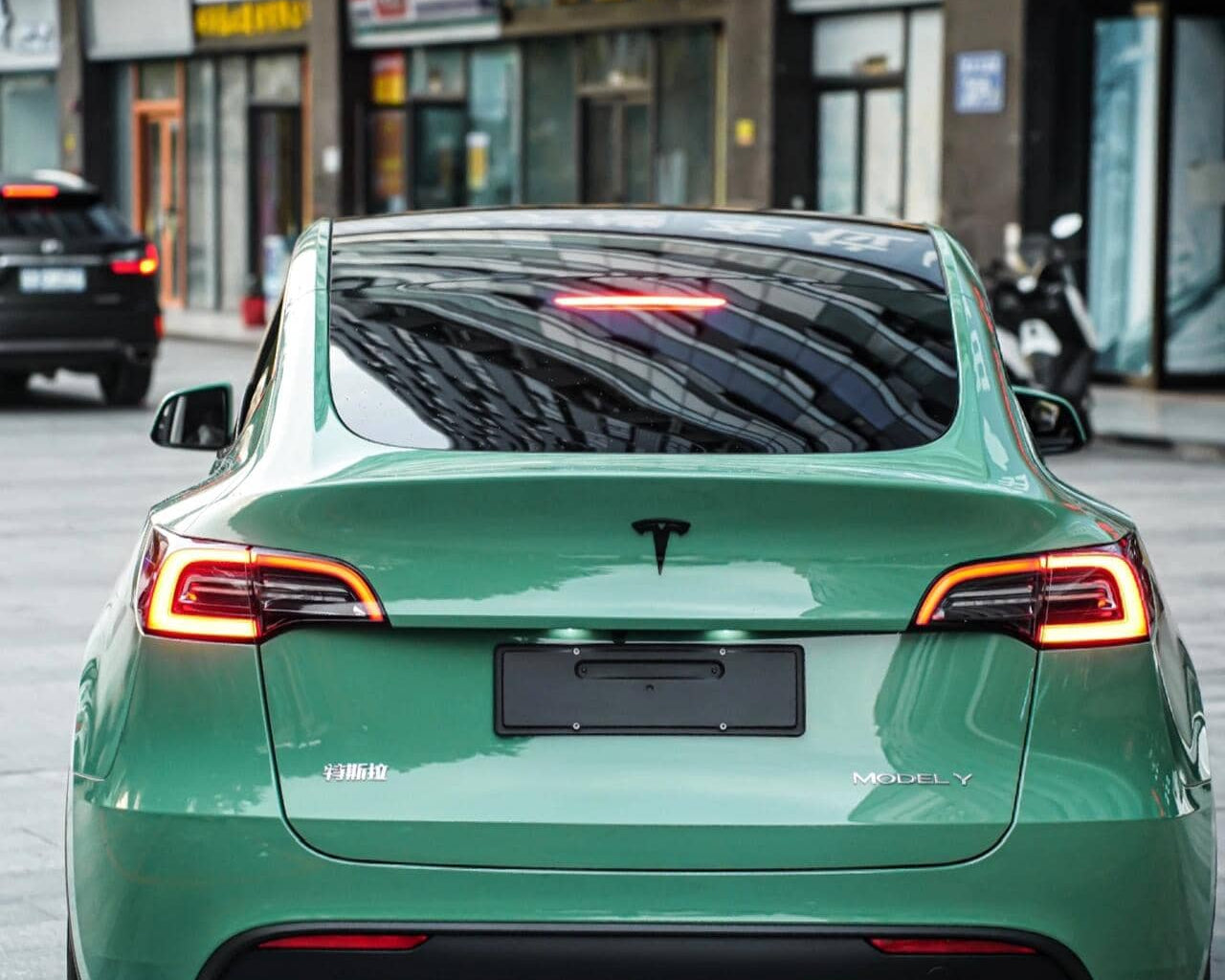 Green Tesla Model Y featuring WrapBug Pre-cut Tesla Vinyl Wrap Kit installed on rear exterior