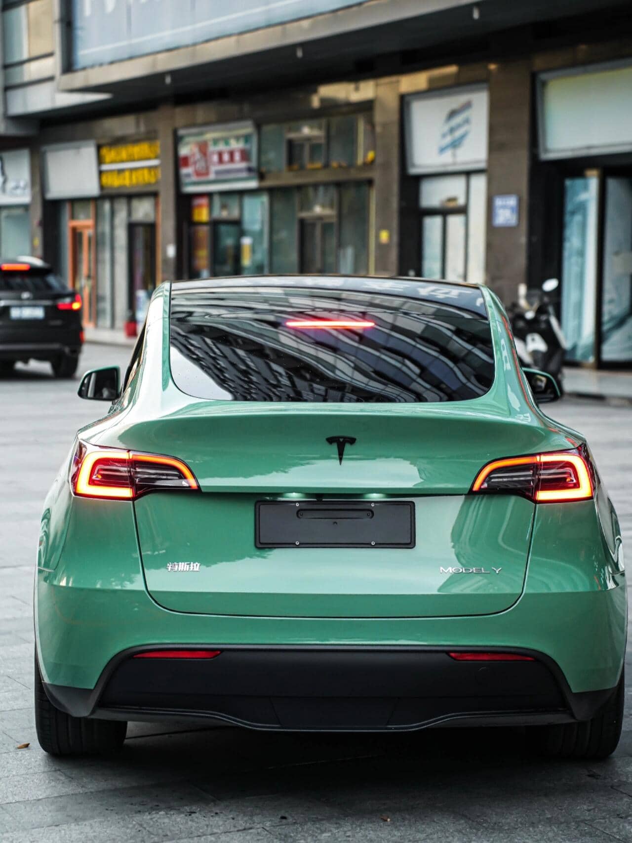 Green Tesla Model Y featuring WrapBug Pre-cut Tesla Vinyl Wrap Kit installed on rear exterior