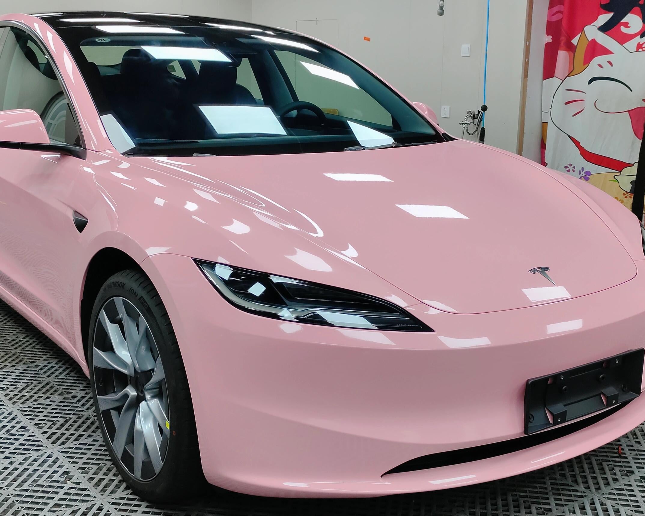 Pink Tesla Model 3 wrapped with WrapBug Pre-cut Tesla Vinyl Wrap Kit in a workshop