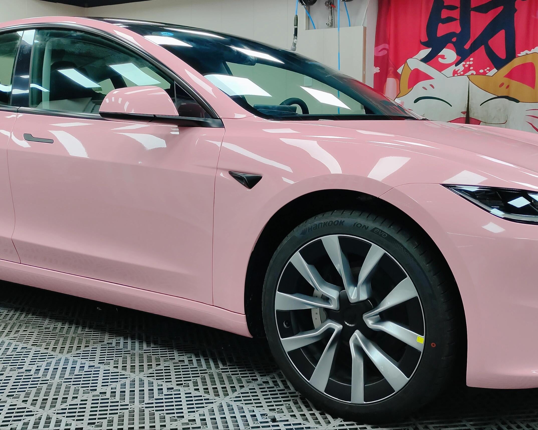 Pink Tesla Model 3 wrapped with WrapBug Pre-cut Tesla Vinyl Wrap Kit in a garage