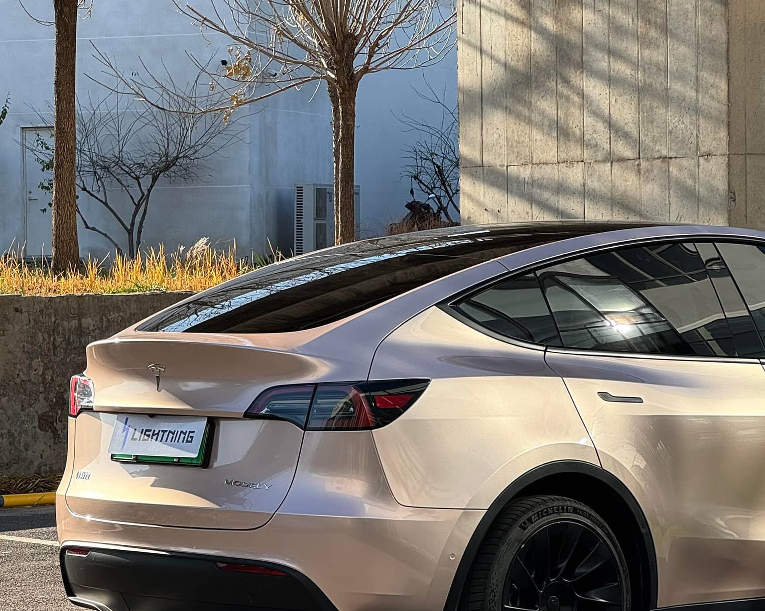 Tesla Model Y with glossy pale pink Pre-cut Tesla Wrap Kit by WrapBug in outdoor parking