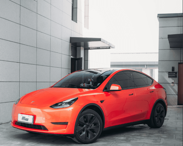 Red Tesla parked outdoors showcasing color from Pre-cut Tesla Wrap Kit by WrapBug