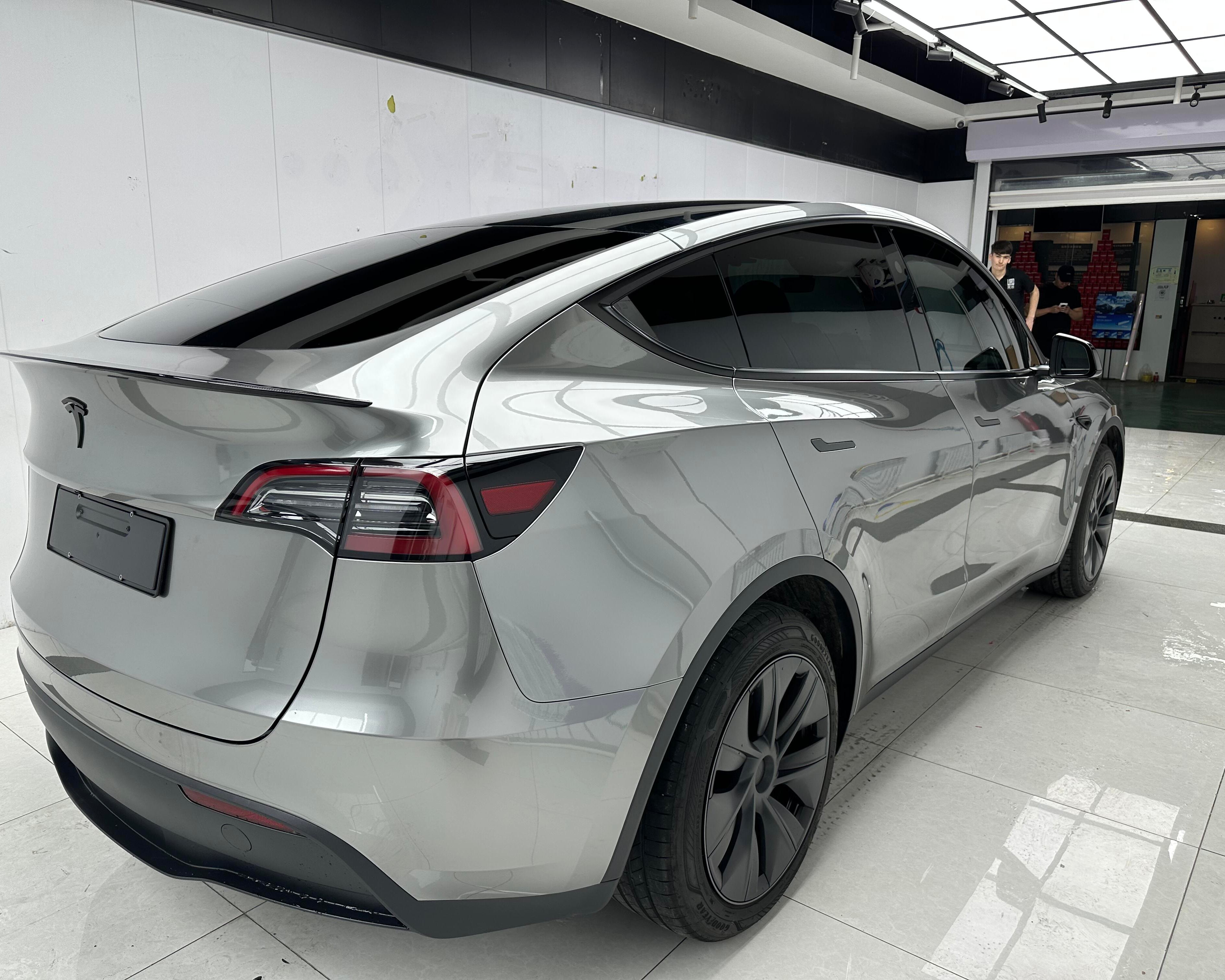 Silver Tesla Model Y featuring a glossy Pre-cut Tesla Wrap Kit from WrapBug in a clean garage