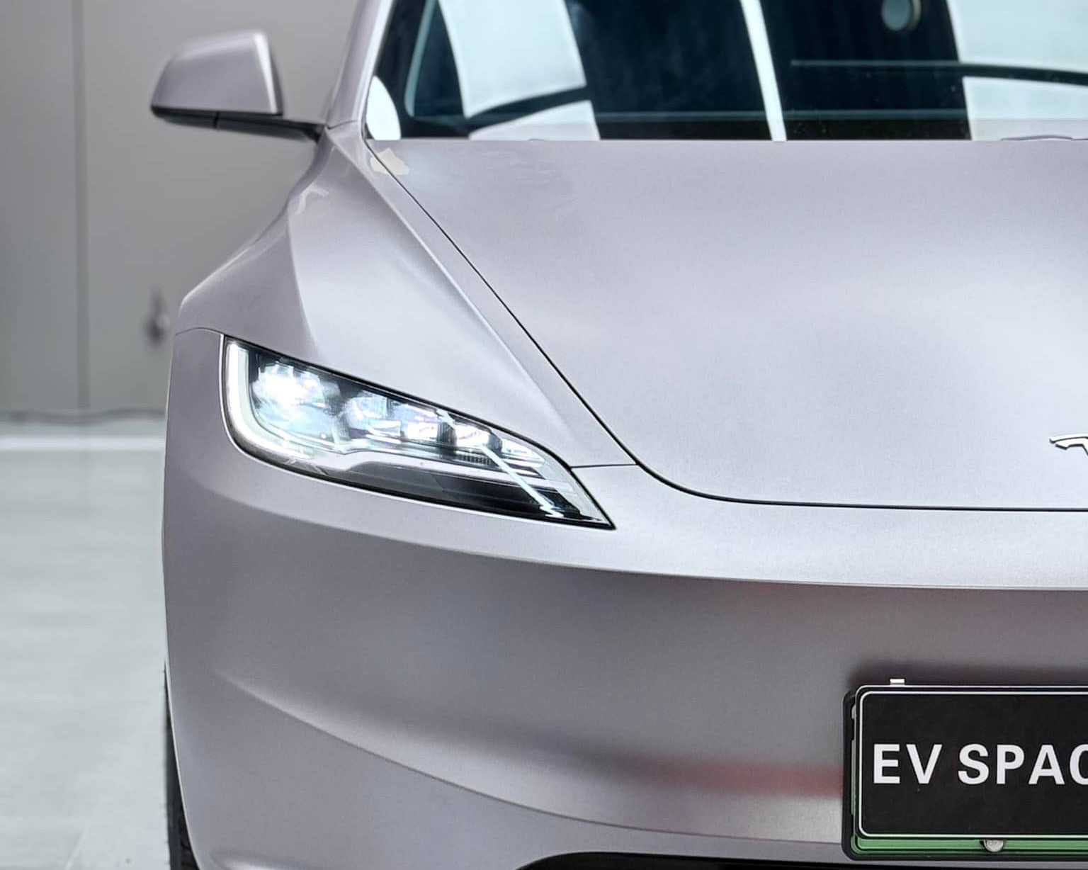 Front view of a Tesla car featuring a smooth silver tesla vinyl wrap with sleek headlights