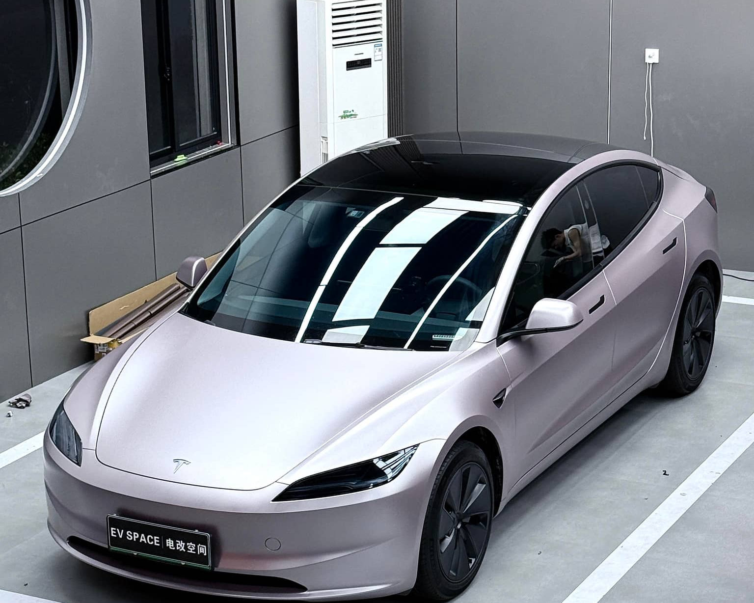 Tesla car wrapped with sleek matte tesla vinyl wrap parked indoors in modern garage