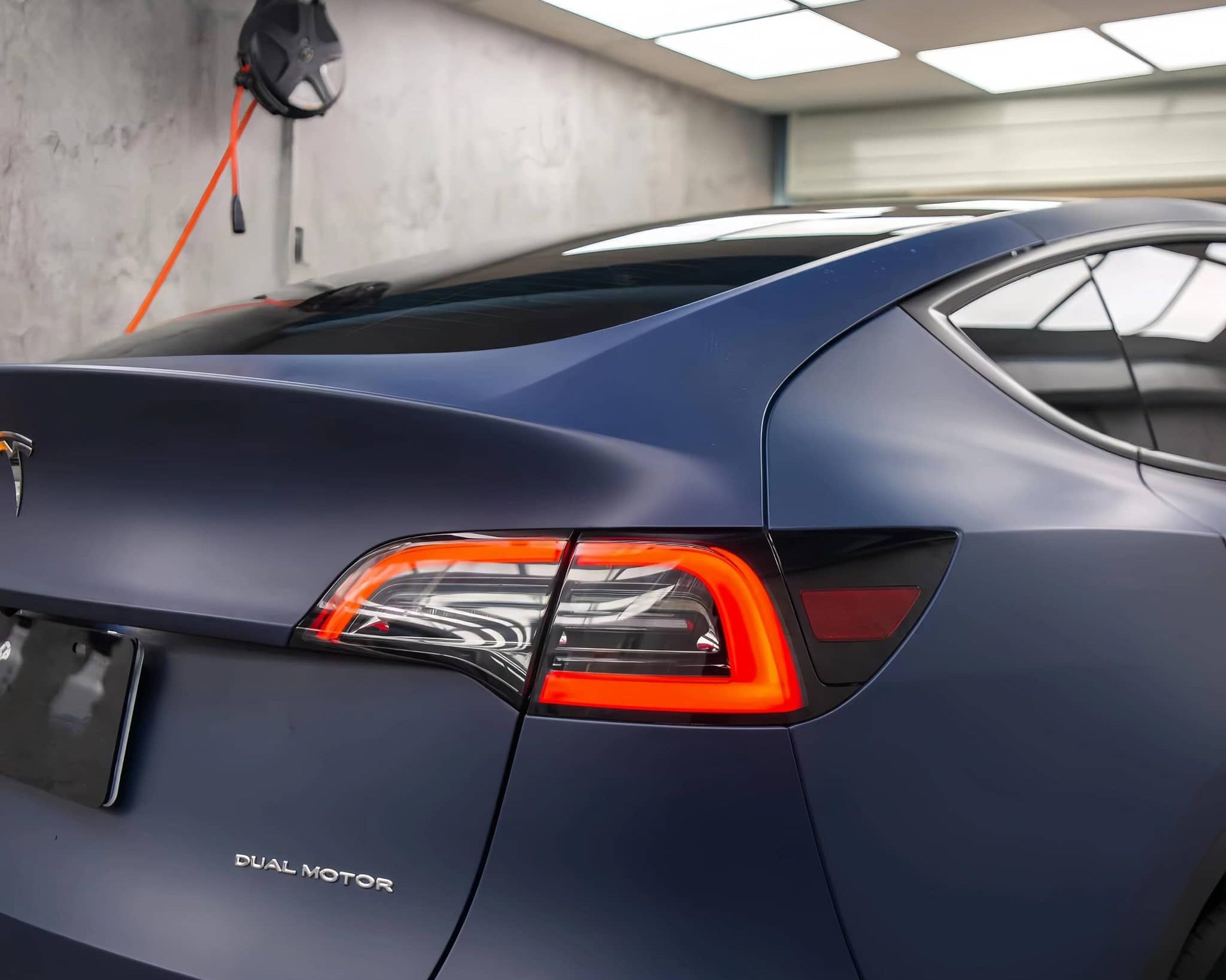 Tesla Model 3 with matte blue tesla vinyl wrap highlighting sleek rear design and taillights