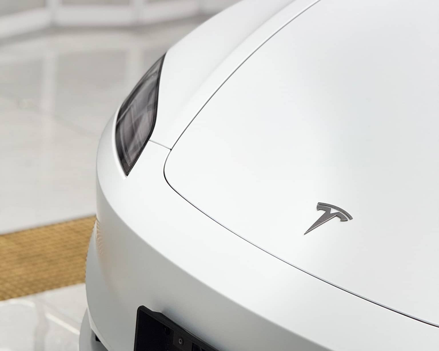 Close-up of white Tesla front with Pre-cut Tesla Vinyl Wrap Kit enhancing the car's sleek look