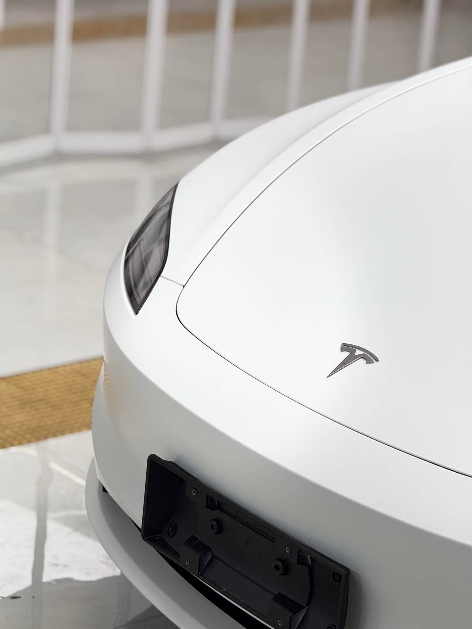 Close-up of white Tesla front with Pre-cut Tesla Vinyl Wrap Kit enhancing the car's sleek look