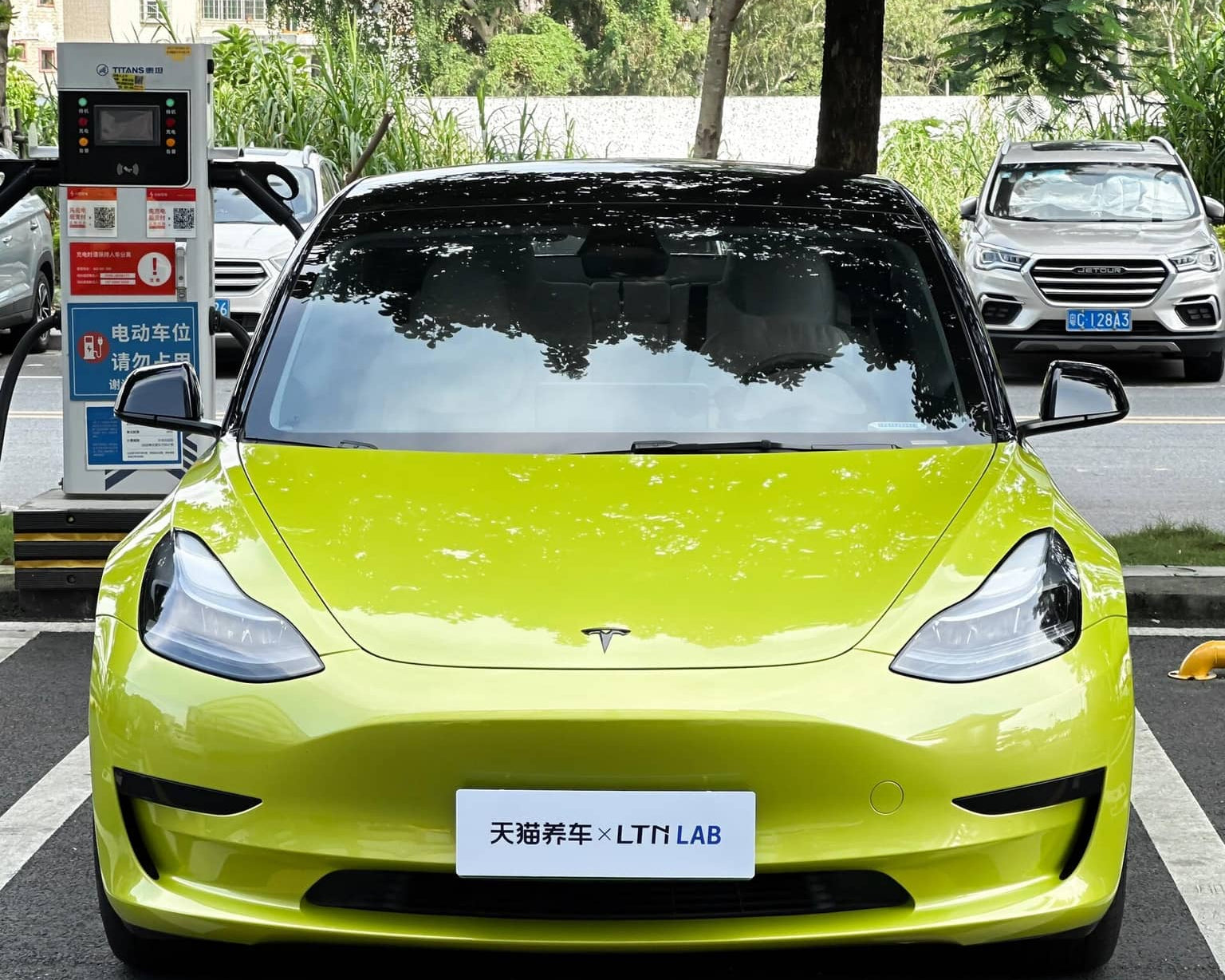 Pre-cut Tesla Vinyl Wrap Kit applied on bright green Tesla Model 3 front view in parking lot