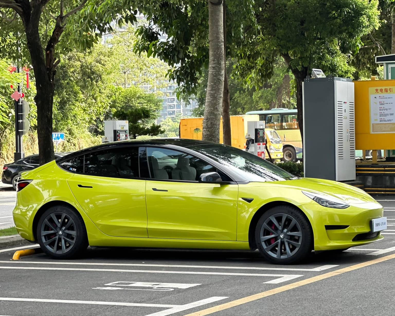 Tesla Model 3 wrapped in bright yellow using Pre-cut Tesla Vinyl Wrap Kit parked on city street