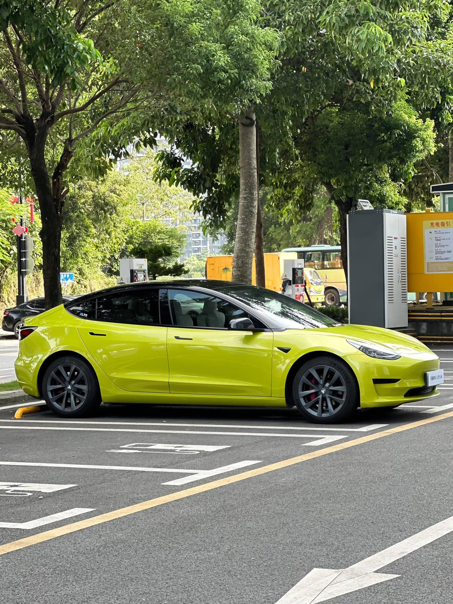 Tesla Model 3 wrapped in bright yellow using Pre-cut Tesla Vinyl Wrap Kit parked on city street
