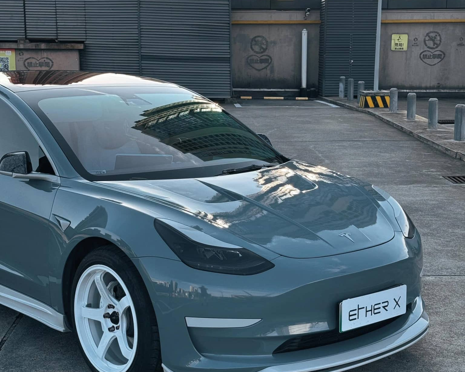 Gray Tesla Model 3 with a Pre-cut Tesla Vinyl Wrap Kit by WrapBug parked in an urban setting