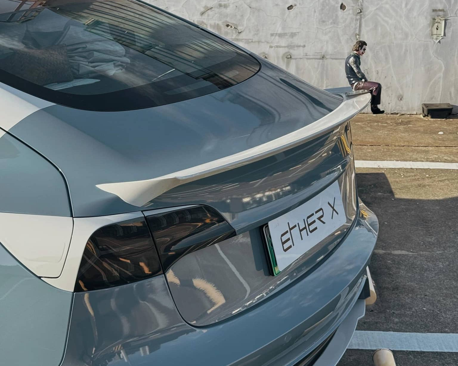 WrapBug pre-cut Tesla vinyl wrap kit applied on rear of gray Tesla with spoiler and ETH-ER X plate