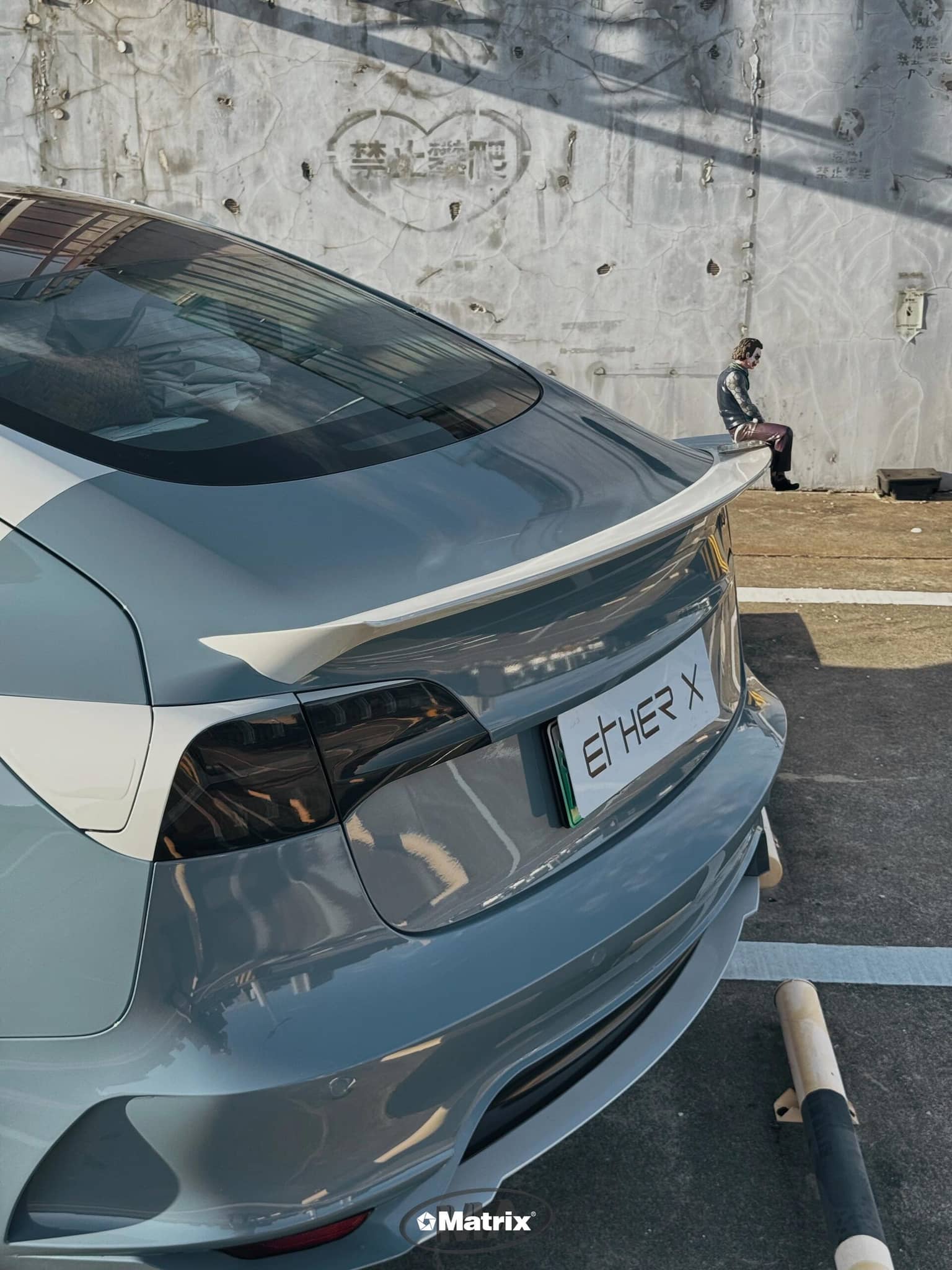 WrapBug pre-cut Tesla vinyl wrap kit applied on rear of gray Tesla with spoiler and ETH-ER X plate
