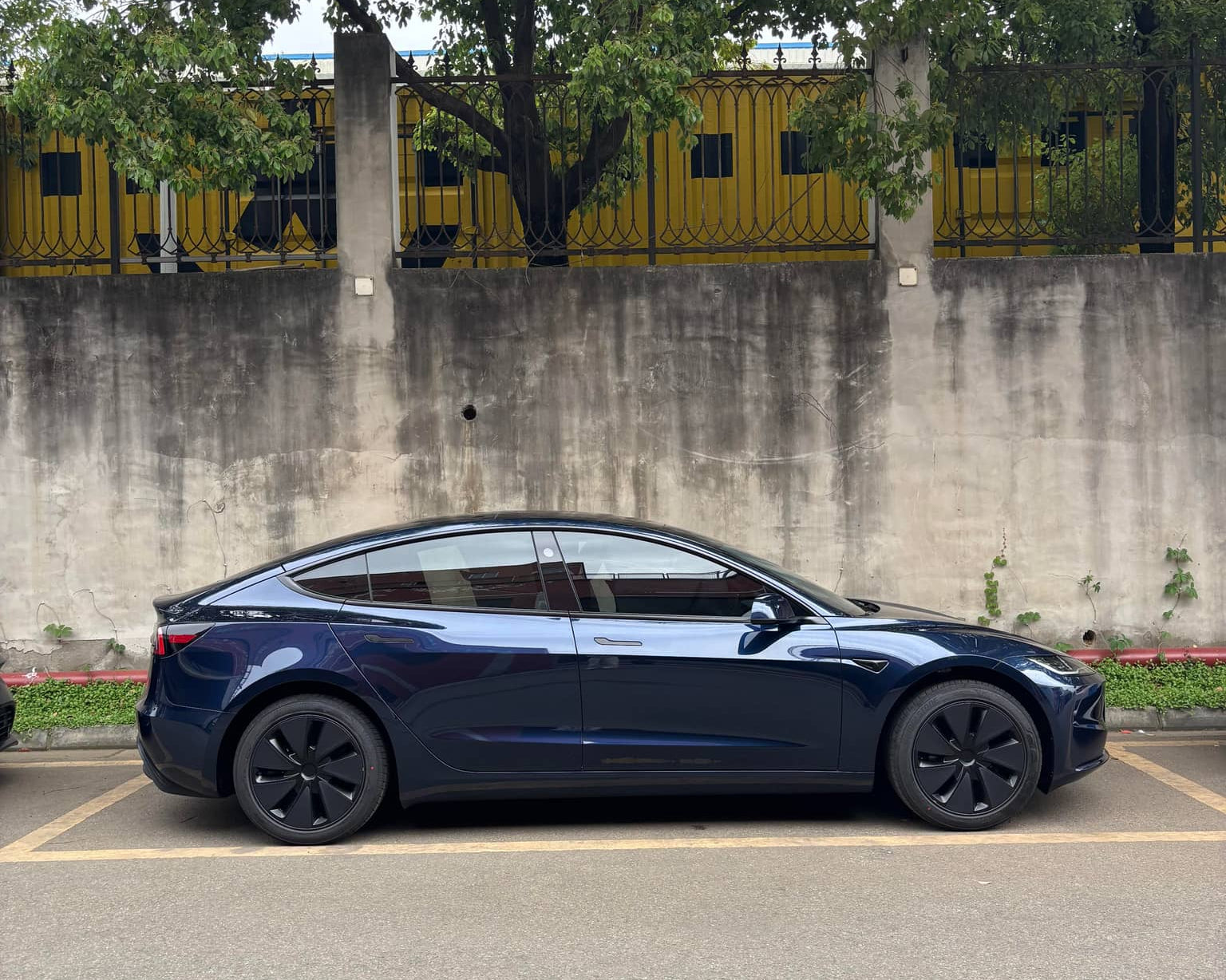 Black Tesla Model 3 parked on street with Pre-cut Tesla Wrap Kit by WrapBug applied
