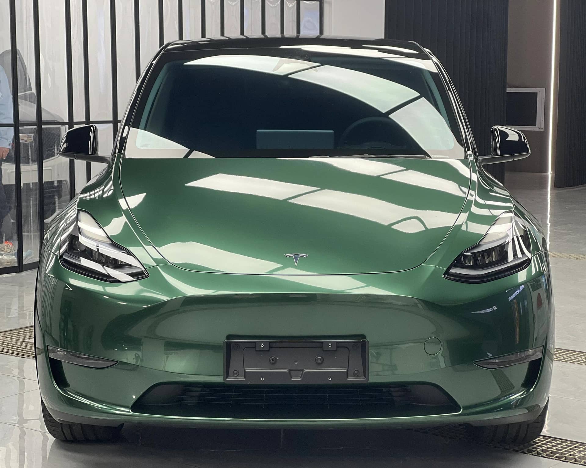 Green Tesla Model Y with shiny finish showcasing WrapBug Pre-cut Tesla Wrap Kit for vehicle customization
