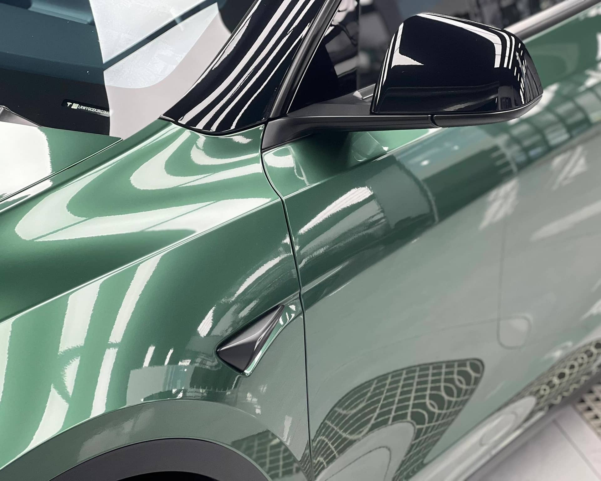 Close-up of green Tesla with glossy finish using Pre-cut Tesla Wrap Kit by WrapBug