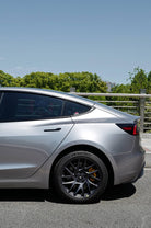 Silver Tesla Model 3 with a Pre-cut Tesla Wrap Kit installed on rear side and black wheels
