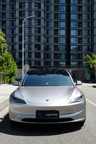 Silver Tesla Model 3 with Pre-cut Tesla Wrap Kit by WrapBug parked in urban street