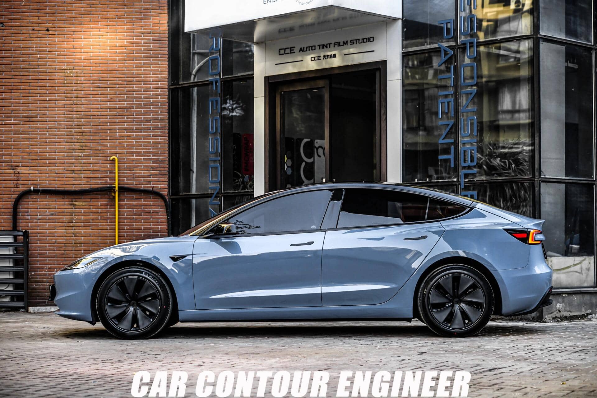 Light blue Tesla Model 3 parked outside shop featuring WrapBug Pre-cut Tesla Vinyl Wrap Kit