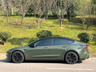 WrapBug olive green car wrap applied on a Tesla Model 3 parked on the street