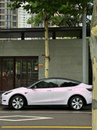 WrapBug pink car wrap on white Tesla Model Y parked on city street