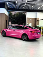 Tesla car wrapped in bright pink Pre-cut Tesla Vinyl Wrap parked indoors