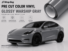 WrapBug pre-cut Tesla vinyl wrap kit in glossy warship gray showing a wrapped Tesla car and vinyl roll