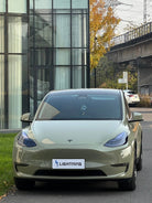 Tesla Model 3 with olive green pre-cut Tesla vinyl wrap kit parked in urban setting